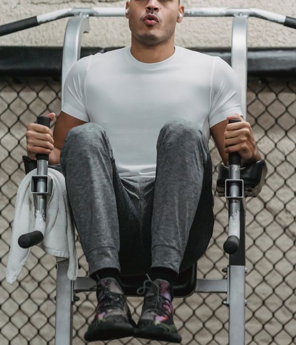 Man performing a core strength exercise in a modern gym.